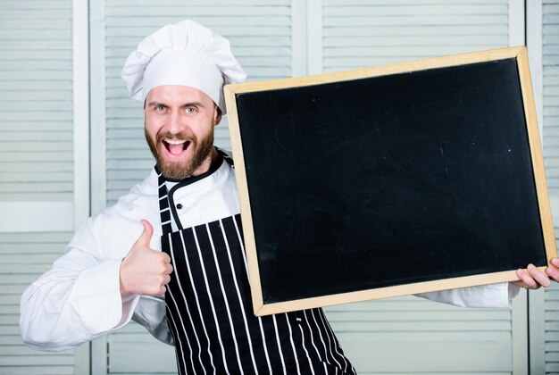 Kciuki w górę za naszą szkołę gastronomiczną Mistrz kucharz udziela lekcji gotowania Szef kucharz prowadzi klasę mistrzowską w szkole gotowania Edukacja w zakresie gotowania i przygotowywania posiłków Mężczyzna trzymający miejsce na tablicę