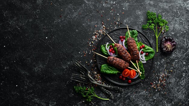 Kebab Tradycyjny bliskowschodni arabski lub śródziemnomorski kebab mięsny z warzywami i ziołami Widok z góry Wolne miejsce na tekst