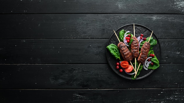 Kebab Tradycyjny bliskowschodni arabski lub śródziemnomorski kebab mięsny z warzywami i ziołami Widok z góry Wolne miejsce na tekst