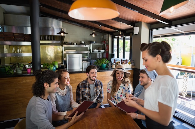 Kelnerka przyjmuje zamówienia od klientów w restauracji