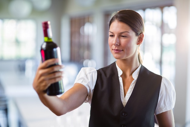 Kelnerka trzyma butelkę wina