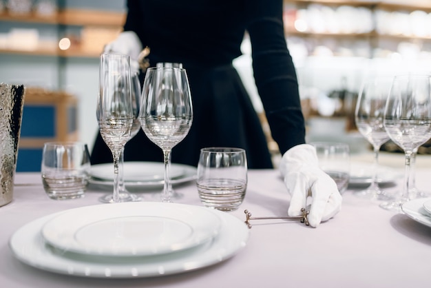 Zdjęcie kelnerka w rękawiczkach stawia naczynia