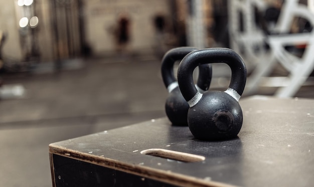 Kettlebells na drewnianym pudełku na siłowni Niewyraźne tło