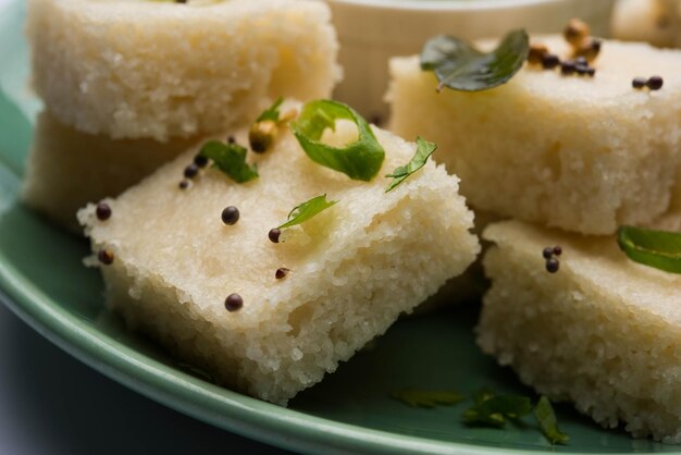 Zdjęcie khaman white dhokla składająca się z ryżu lub urad dal to popularny przepis na śniadanie lub przekąski z gujarat w indiach, podawany z zielonym chutney i gorącą herbatą. selektywne skupienie