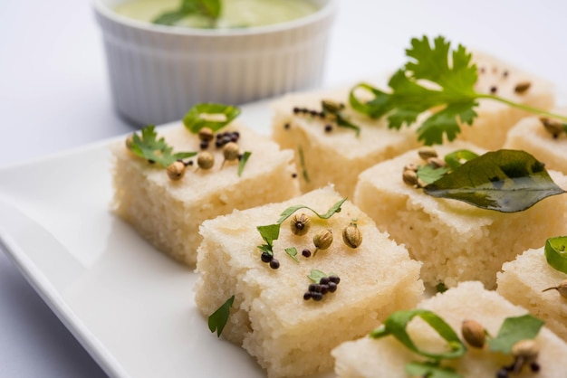 Khaman white Dhokla składająca się z ryżu lub urad dal to popularny przepis na śniadanie lub przekąski z Gujarat w Indiach, podawany z zielonym chutney i gorącą herbatą. Selektywne skupienie