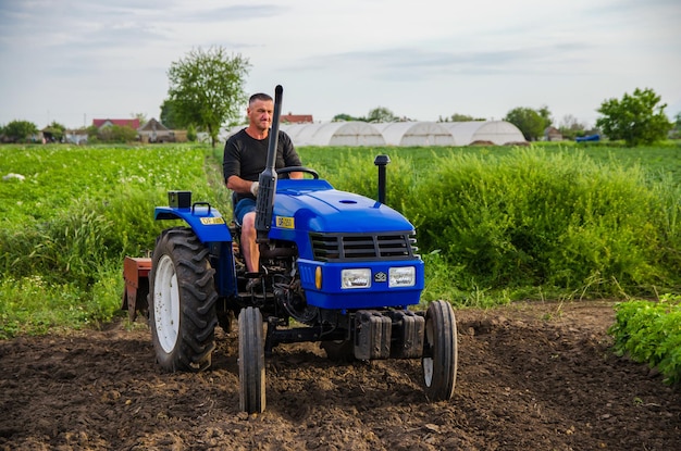 Kherson oblast Ukraina 29 maja 2021 Rolnik na traktorze pracuje na polu Pracownik sezonowy Rekrutacja pracowników z umiejętnościami prowadzenia maszyn rolniczych Młyn ziemi przed cięciem rzędów