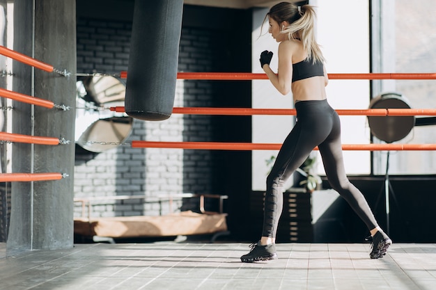 Kickboxing Kobieta W Airpods Trenuje Worek Treningowy W Studiu Fitness Intensywne Dopasowanie Do Ciała