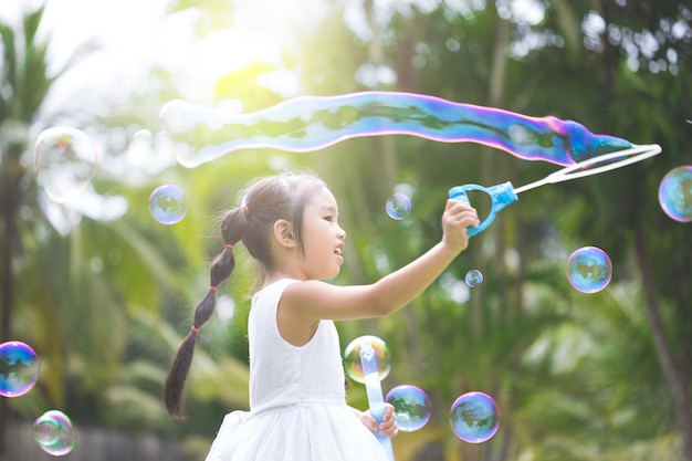 Zdjęcie kid gry i dmuchanie bubbles at the field