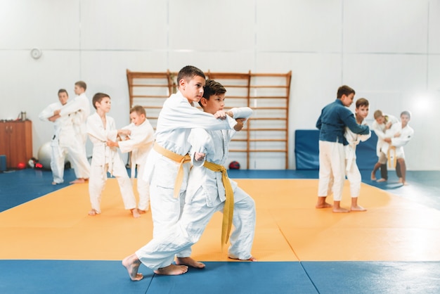 Kid judo, dzieci trenujące sztuki walki w hali. Mali chłopcy w mundurach, młodzi wojownicy