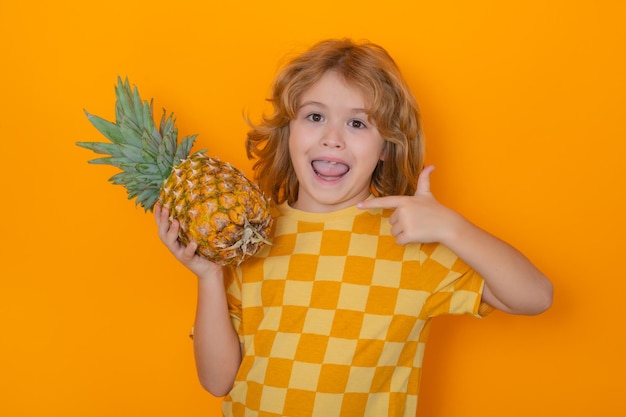 Kid z ananasem w studio Portret studyjny cute ananasa przytrzymaj dziecko samodzielnie na żółtym tle