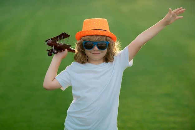 Kid zabawę z samolocikiem zabawki w polu Dziecko pilot aviator z marzeniami samolotu o podróżowaniu