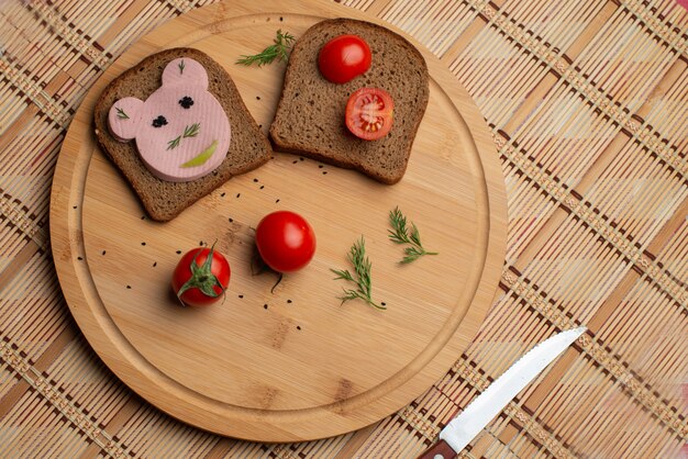 Kiełbasa z czarnym chlebem i tomates na drewnianym tle