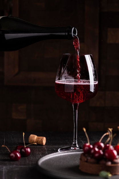 Kieliszek czerwonego wina i deser wiśniowy