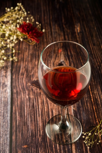 Kieliszek czerwonego wina na rustykalnym, drewnianym stole teksturowanej.