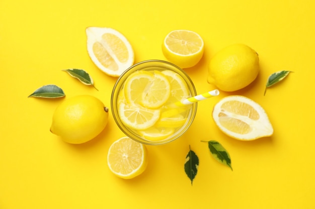 Kieliszek lemoniady i cytryn na żółtym tle