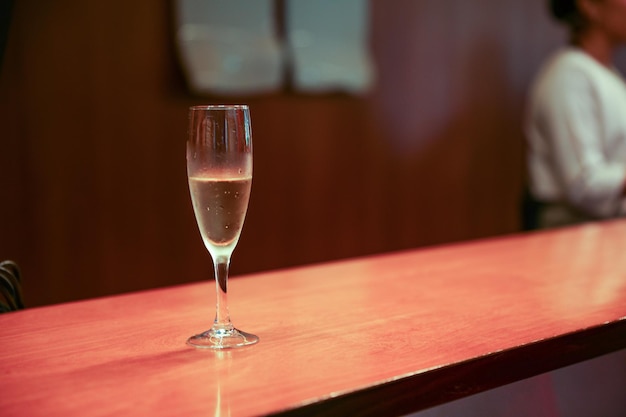 Kieliszek szampana na stole z oknem w tle