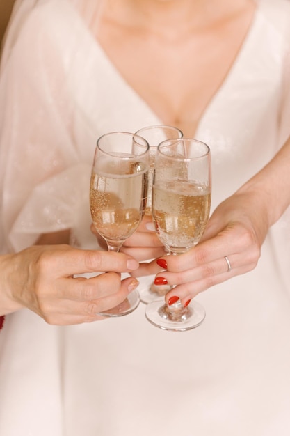 Kieliszek szampana w rękach panny młodej i jej druhen