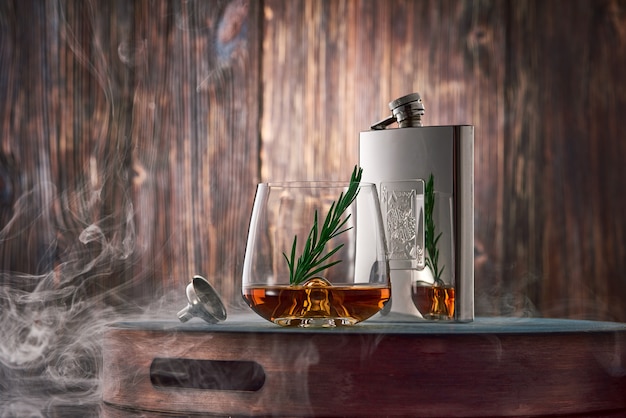 Kieliszek whisky i kolba na drewnianym stole