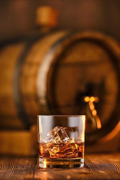 Zdjęcie kieliszek whisky z lodem z beczką