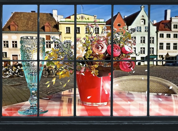 kieliszek wina i filiżanka kawy i świeca na stoliku ulicznym w średniowiecznym mieście Tallin Stare miasto