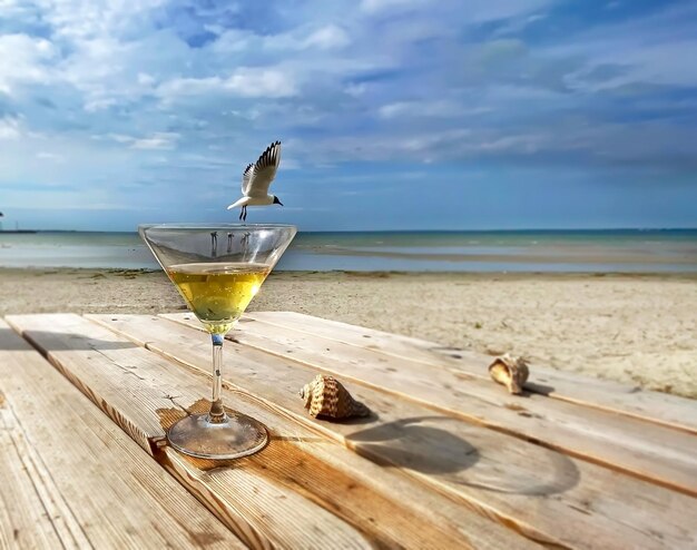 kieliszek wina na stole na plaży błękitne niebo i morze