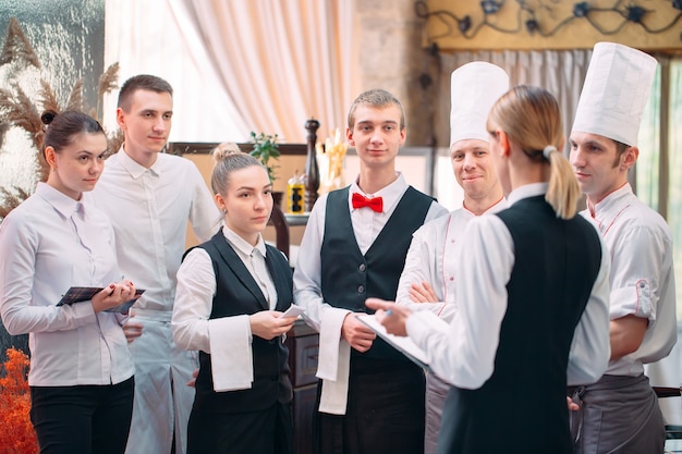 Zdjęcie kierownik restauracji i jego personel w kuchni. interakcja z szefem kuchni w kuchni komercyjnej.