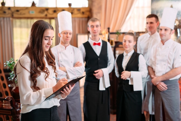 Kierownik restauracji i jego personel w kuchni. interakcja z szefem kuchni w kuchni komercyjnej.