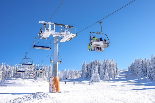 Kiers na wyciągu narciarskim w górskim kurorcie z niebem i górami