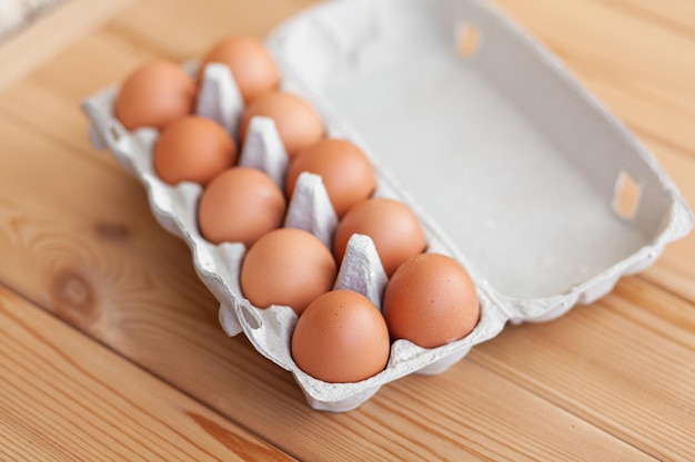 Kilka brązowych jajek wśród komórek dużej tekturowej torby, jajko kurze jako cenny produkt odżywczy, taca do przenoszenia i przechowywania kruchych jajek. Pełne opakowanie jaj, ważny artykuł spożywczy