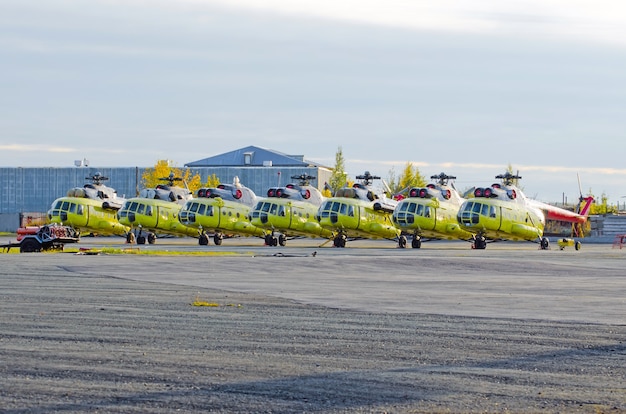 Zdjęcie kilka helikopterów zaparkowanych na lotnisku do naprawy.