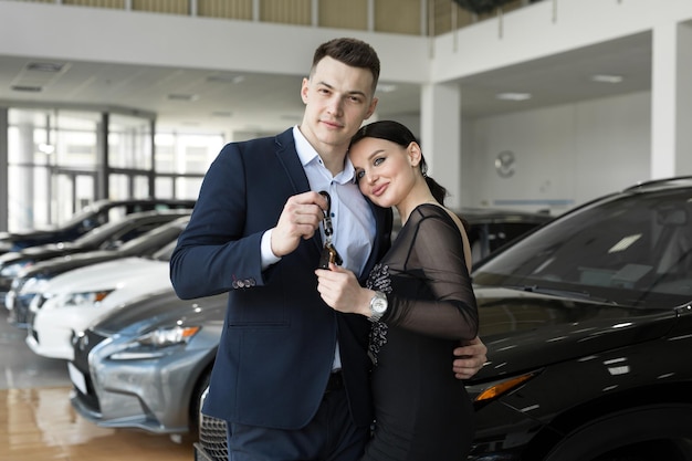 Kilka kobiet i mężczyzn chętnie kupuje nowy samochód w salonie samochodowym