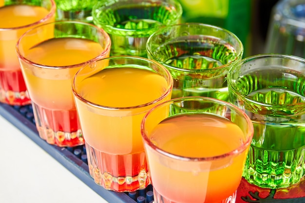 Kilka kolorowych kieliszków napojów alkoholowych na ladzie barowej