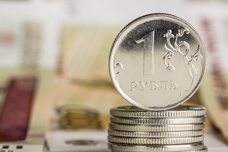 Zdjęcie kilka metalowych monet jednego rubla stojących na rosyjskich papierowych banknotach