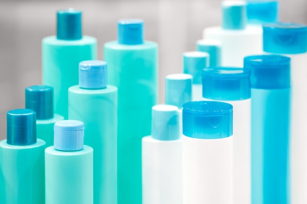 Kilka różnych zbliżeń na biało-turkusową niebieską designerską plastikową butelkę na kosmetyki i perfumy lub inne płyny
