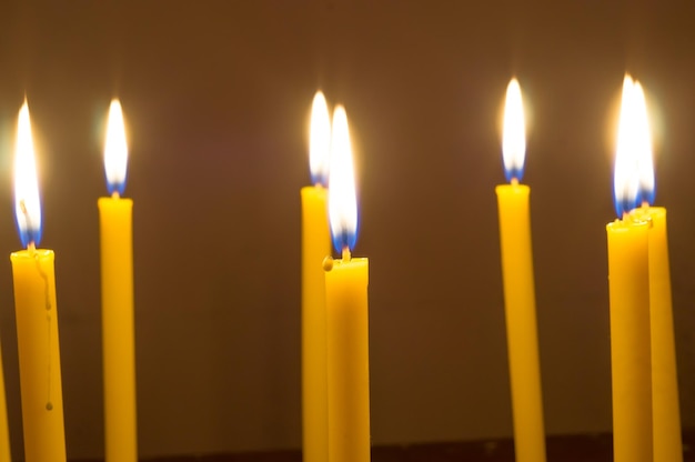 Kilka świecących żółtych świec w ciemnym tle
