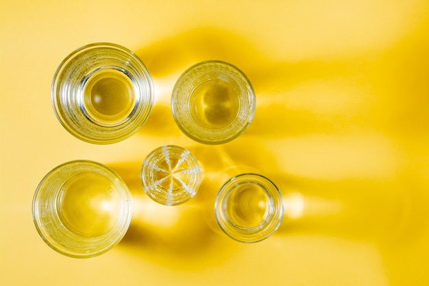 Zdjęcie kilka szklanek wody o różnych kształtach w żółto-szarej palecie
