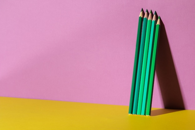 Kilka Zielonych Ołówków Z Cieniem Na Modnym Fioletowym I żółtym Tle. Miejsce Na Tekst