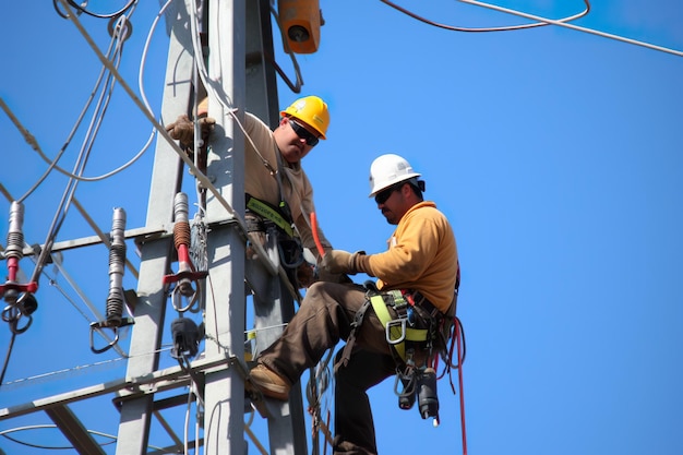 Kilku mężczyzn stojących na szczycie metalowego słupa generatywnego obrazu ai pracowników linii energetycznej