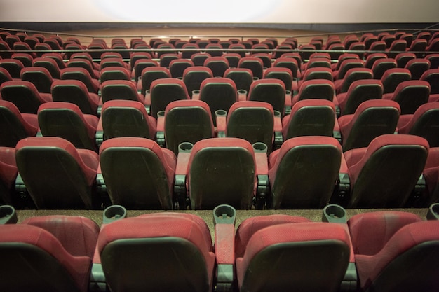 Kino z czerwonymi siedzeniami i białym ekranem