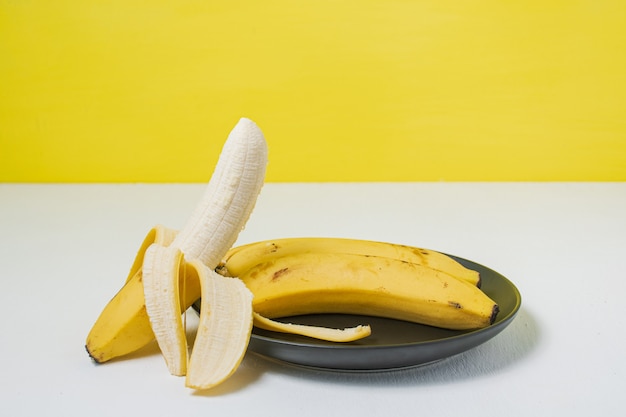 Zdjęcie kiść bananów i otwarty banan na białym tle