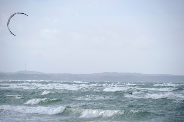 Kitesurfing na falach deski podczas burzy trzymającej latawiec