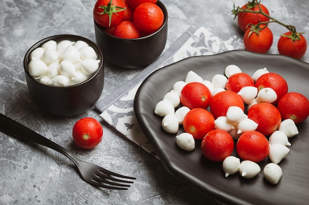 Klasyczna włoska sałatka caprese z pomidorami wiśniowymi, mozarellą, perłami, liśćmi bazylii i glazurą balsamiczną