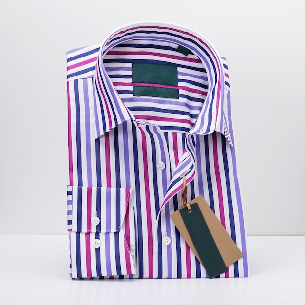 Klasyczna złożona koszula męska w kolorowych paskach z długimi rękawami na jasnym tle