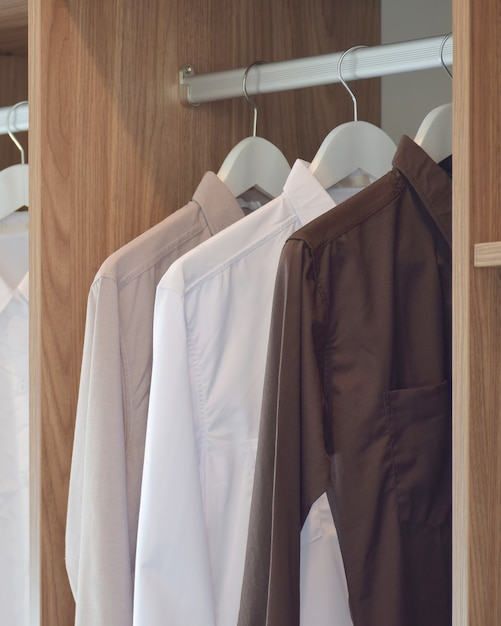Klasyczne koszule wiszące w drewnianej szafie