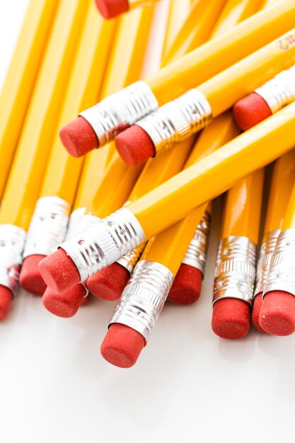 Klasyczne żółte ołówki z czerwoną gumką na białym tle.