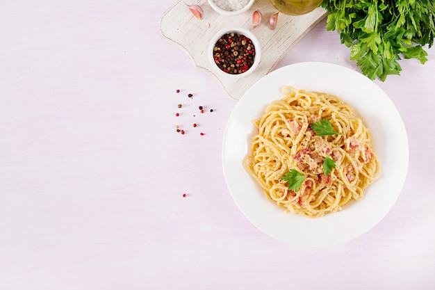 Klasyczny domowy makaron carbonara z pancettą, jajkiem, twardym parmezanem i sosem śmietanowym.