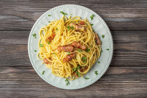 Klasyczny domowy makaron carbonara z spaghetti pancetta jajko z parmezanem i sosem śmietanowym na drewnianym stole Włoskie jedzenie widok z góry