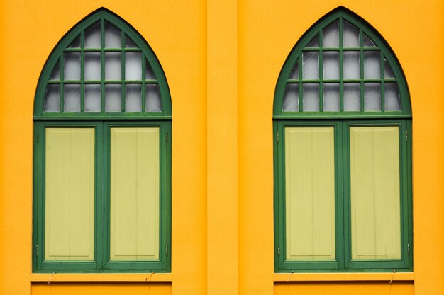 Klasyczny drewniany okno przy żółtym betonowym budynkiem