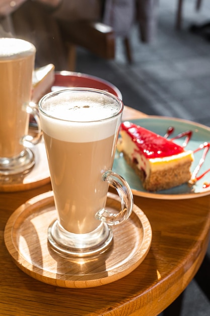 Klasyczny sernik nowojorski i kawa latte na stole w kawiarni. Widok z góry.