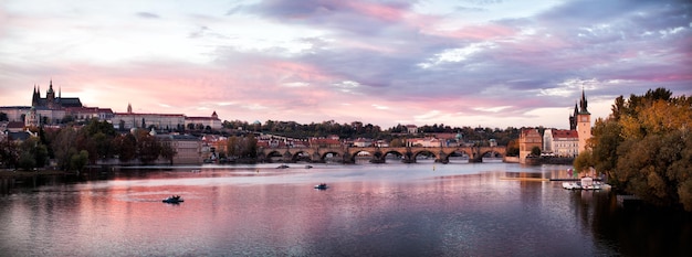 Klasyczny widok na Most Karola i Wełtawę w Pradze, Czechy o zachodzie słońca